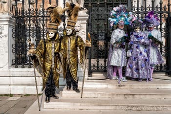 People in costume at the Venice Carnival in front of the Venetian Arsenal.