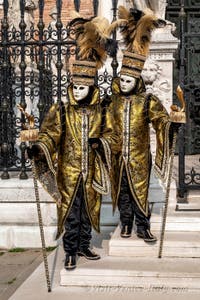 People in costume at the Venice Carnival in front of the Venetian Arsenal.