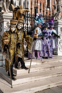 People in costume at the Venice Carnival in front of the Venetian Arsenal.