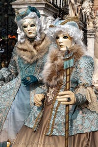 People in costume at the Venice Carnival in front of the Venetian Arsenal.