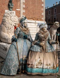 People in costume at the Venice Carnival in front of the Venetian Arsenal.