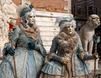 People in costume at the Venice Carnival in front of the Venetian Arsenal.