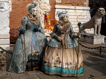 People in costume at the Venice Carnival in front of the Venetian Arsenal.