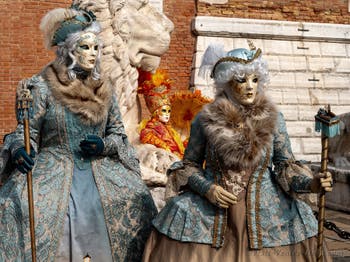 People in costume at the Venice Carnival in front of the Venetian Arsenal.