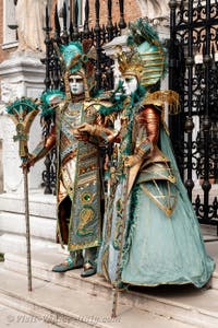 People in costume at the Venice Carnival in front of the Venetian Arsenal.