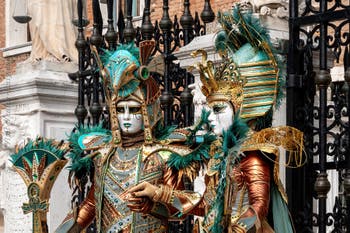 People in costume at the Venice Carnival in front of the Venetian Arsenal.