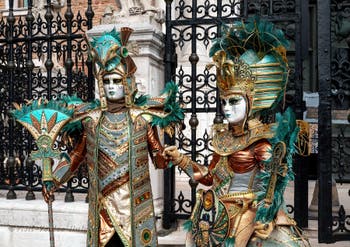 People in costume at the Venice Carnival in front of the Venetian Arsenal.