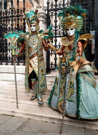 People in costume at the Venice Carnival in front of the Venetian Arsenal.