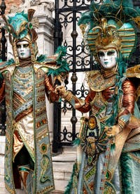 People in costume at the Venice Carnival in front of the Venetian Arsenal.