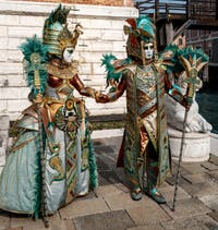 People in costume at the Venice Carnival in front of the Venetian Arsenal.