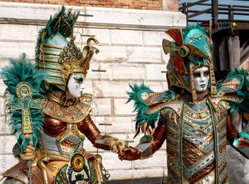 People in costume at the Venice Carnival in front of the Venetian Arsenal.