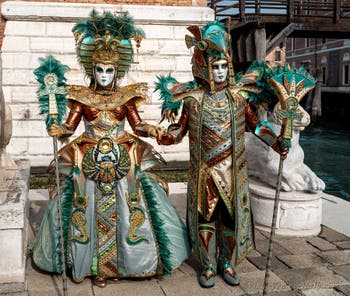 People in costume at the Venice Carnival in front of the Venetian Arsenal.