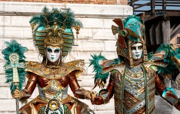 People in costume at the Venice Carnival in front of the Venetian Arsenal.