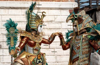 People in costume at the Venice Carnival in front of the Venetian Arsenal.