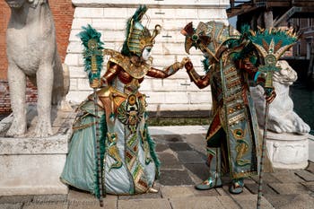 People in costume at the Venice Carnival in front of the Venetian Arsenal.