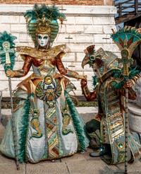 People in costume at the Venice Carnival in front of the Venetian Arsenal.