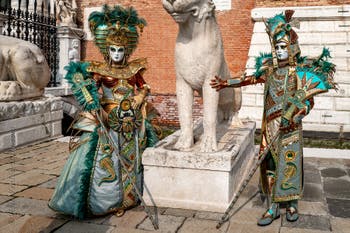 People in costume at the Venice Carnival in front of the Venetian Arsenal.