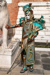 People in costume at the Venice Carnival in front of the Venetian Arsenal.