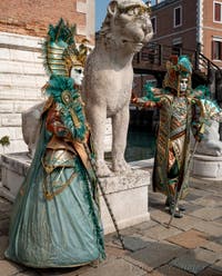 People in costume at the Venice Carnival in front of the Venetian Arsenal.