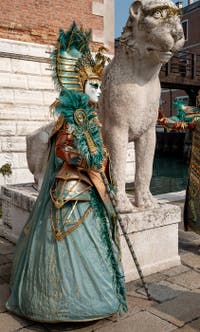 People in costume at the Venice Carnival in front of the Venetian Arsenal.