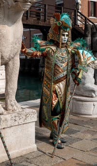 People in costume at the Venice Carnival in front of the Venetian Arsenal.