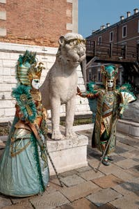 People in costume at the Venice Carnival in front of the Venetian Arsenal.