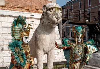 People in costume at the Venice Carnival in front of the Venetian Arsenal.