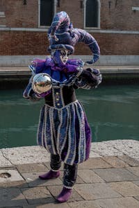 People in costume at the Venice Carnival in front of the Venetian Arsenal.