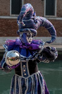 People in costume at the Venice Carnival in front of the Venetian Arsenal.