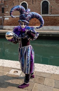 People in costume at the Venice Carnival in front of the Venetian Arsenal.