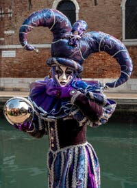 People in costume at the Venice Carnival in front of the Venetian Arsenal.