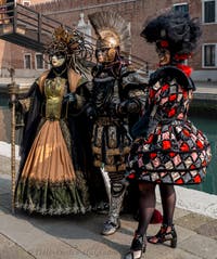 People in costume at the Venice Carnival in front of the Venetian Arsenal.