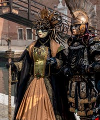 People in costume at the Venice Carnival in front of the Venetian Arsenal.