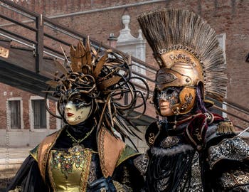 People in costume at the Venice Carnival in front of the Venetian Arsenal.