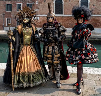 People in costume at the Venice Carnival in front of the Venetian Arsenal.