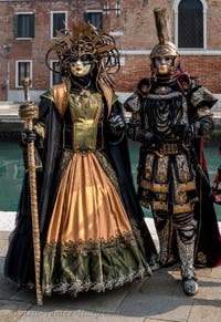 People in costume at the Venice Carnival in front of the Venetian Arsenal.