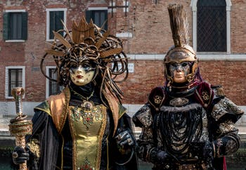 People in costume at the Venice Carnival in front of the Venetian Arsenal.