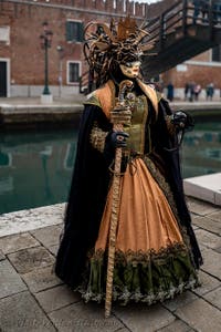 People in costume at the Venice Carnival in front of the Venetian Arsenal.