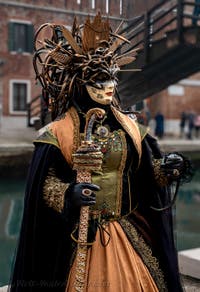 People in costume at the Venice Carnival in front of the Venetian Arsenal.