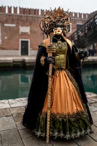 People in costume at the Venice Carnival in front of the Venetian Arsenal.