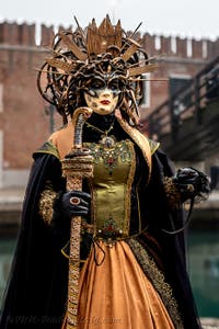 People in costume at the Venice Carnival in front of the Venetian Arsenal.