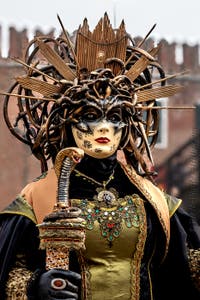 People in costume at the Venice Carnival in front of the Venetian Arsenal.