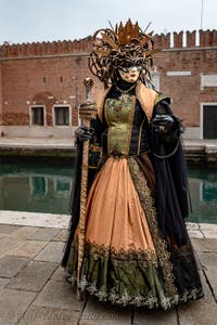 People in costume at the Venice Carnival in front of the Venetian Arsenal.