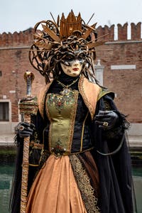 People in costume at the Venice Carnival in front of the Venetian Arsenal.