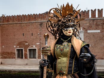 People in costume at the Venice Carnival in front of the Venetian Arsenal.