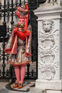 People in costume at the Venice Carnival in front of the Venetian Arsenal.