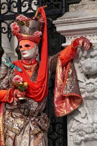 People in costume at the Venice Carnival in front of the Venetian Arsenal.