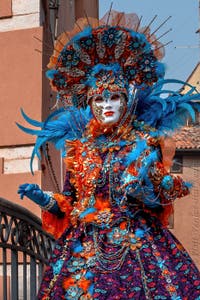 People in costume at the Venice Carnival in front of the Venetian Arsenal.