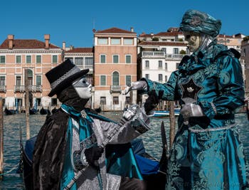 People in costume at the Venice carnival in front of the Madonna della Salute.