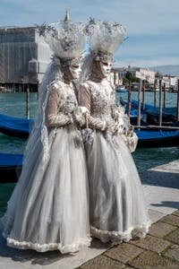 People in costume at the Venice carnival in front of the Madonna della Salute.